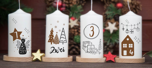 Adventskranzkerzen mit den Zahlen 1 bis 4 vor einem Adventskranz