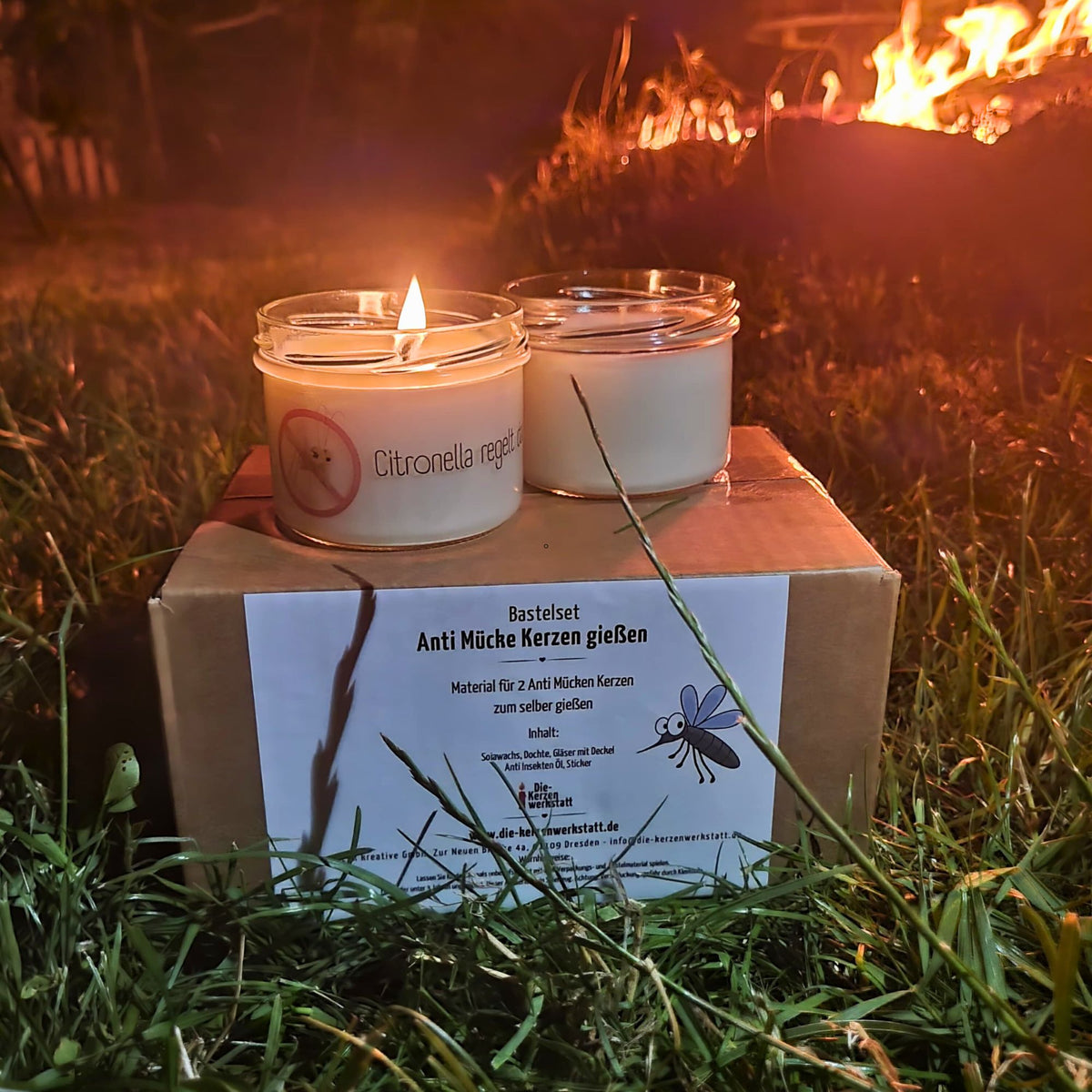 Brennende Citronella-Kerzen am Abend neben dem Feuer im Garten