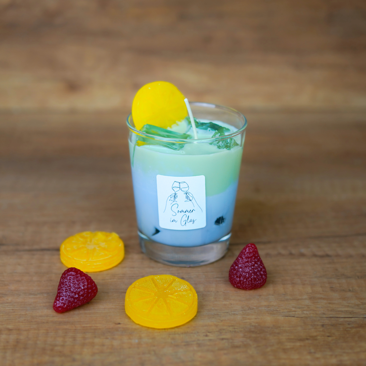 Zwei sommerliche Cocktailkerzen in Blau und Grün mit gegossenen Fruchtscheiben