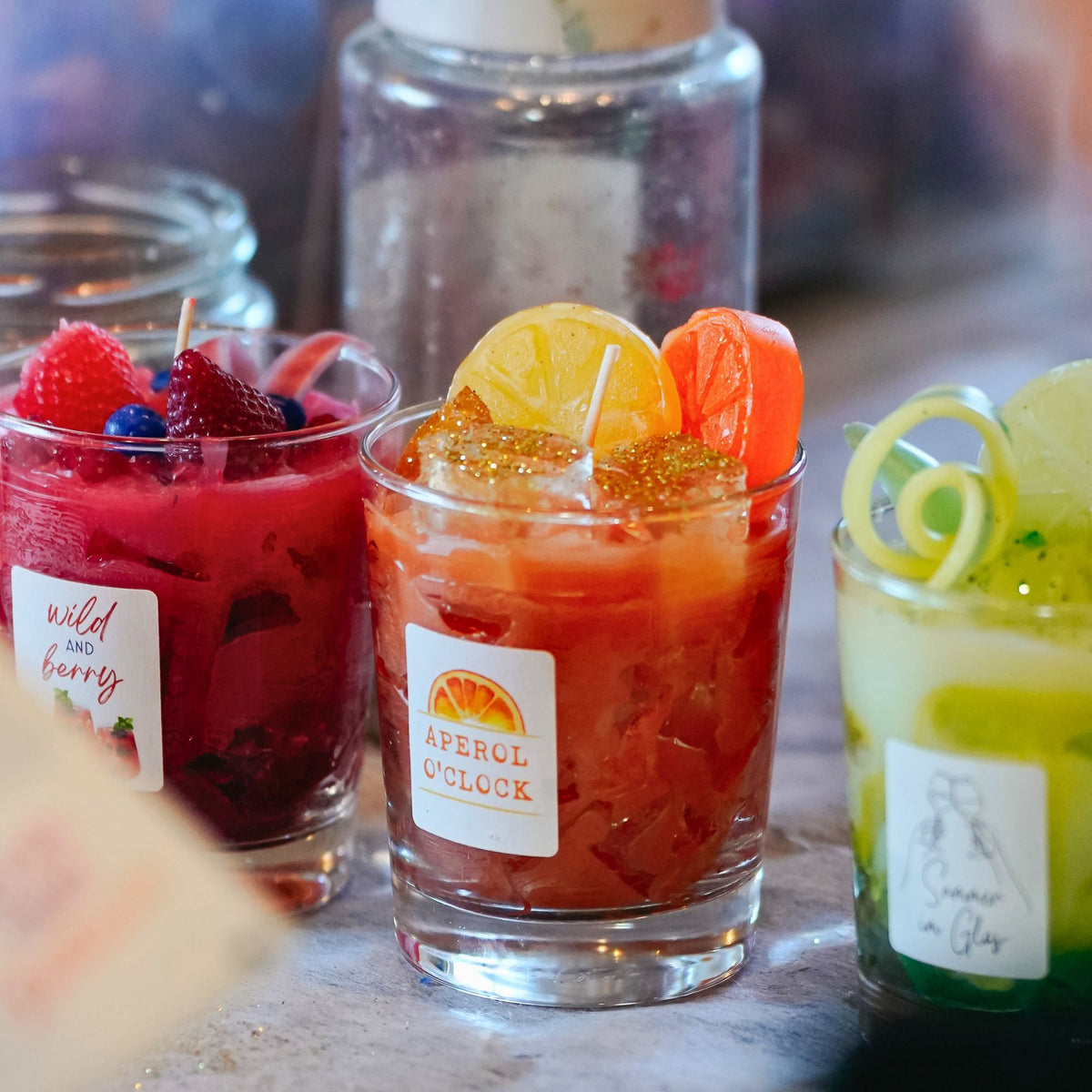 Bunte DIY-Cocktailkerzen mit Wachsfrüchten auf einem gedeckten Tisch