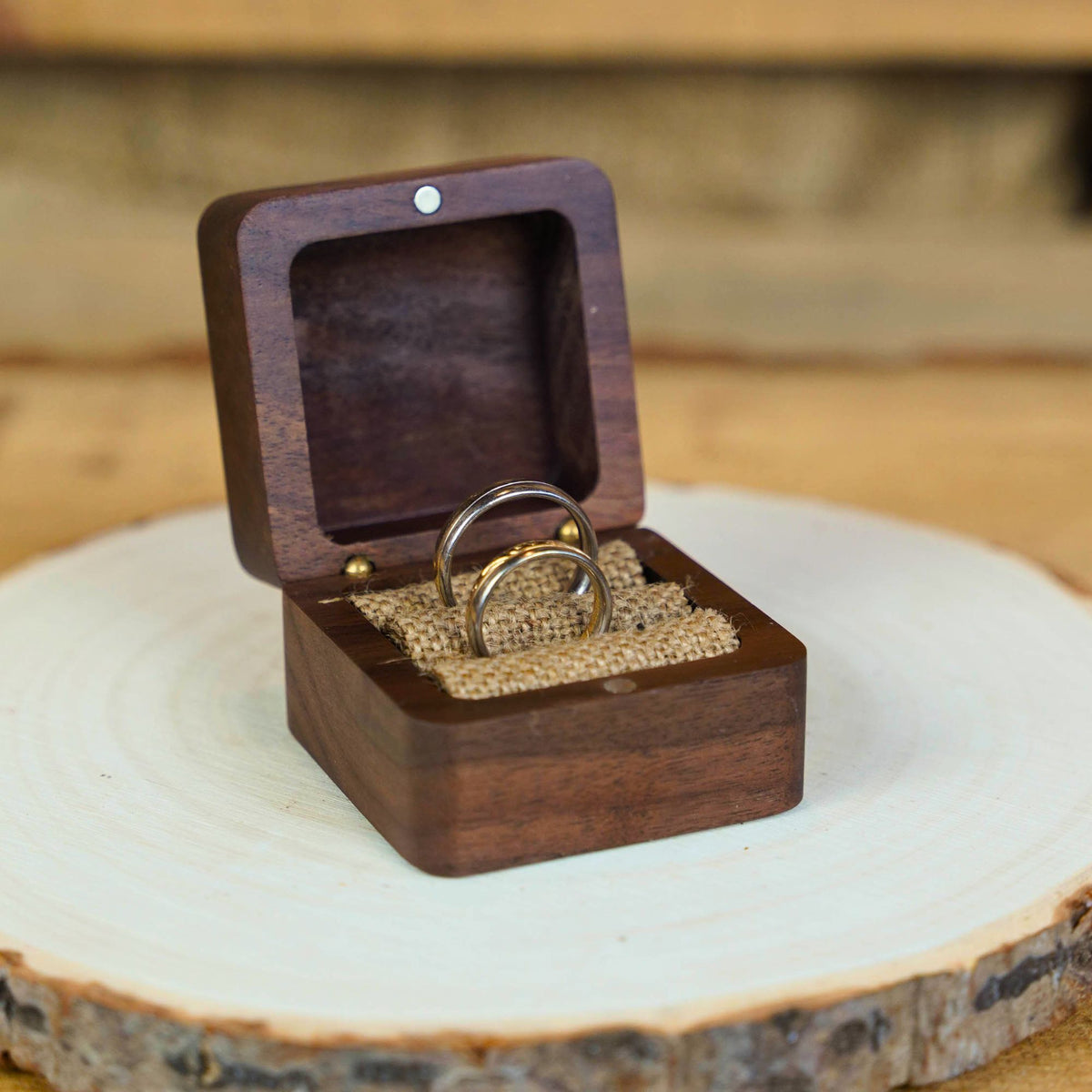 Ringe in Ringkiste Walnussholz auf Holzscheibe
