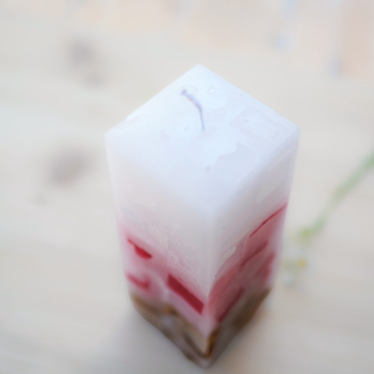 Nahaufnahme der quadratischen Kerze mit Wachswürfeln in Creme und Rosa