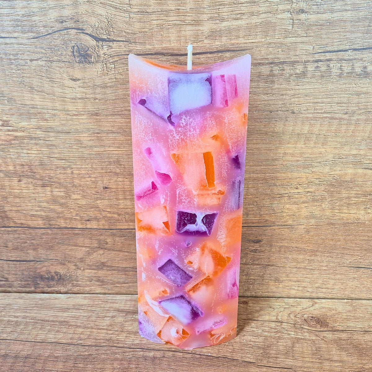 Ovale Wachswürfelkerze Pink Power mit orangefarbenen Würfeln