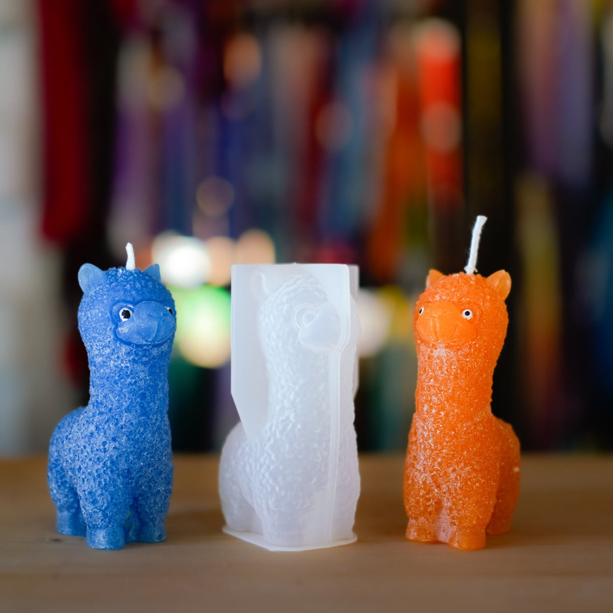 Blaue und orange Alpaka-Kerze neben der Silikonform für die Herstellung