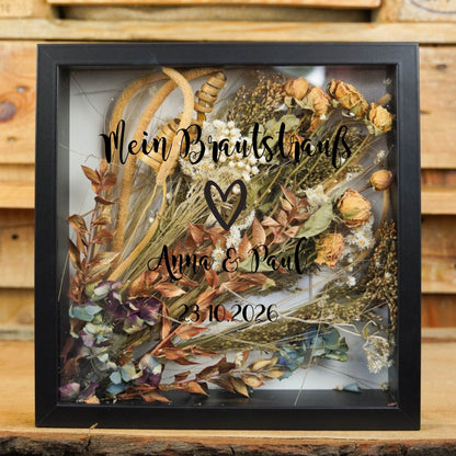 Schwarzer Brautstraußrahmen mit Herz, „Mein Brautstrauß“, Namen und Datum in schwarzer Schrift über Trockenblumen