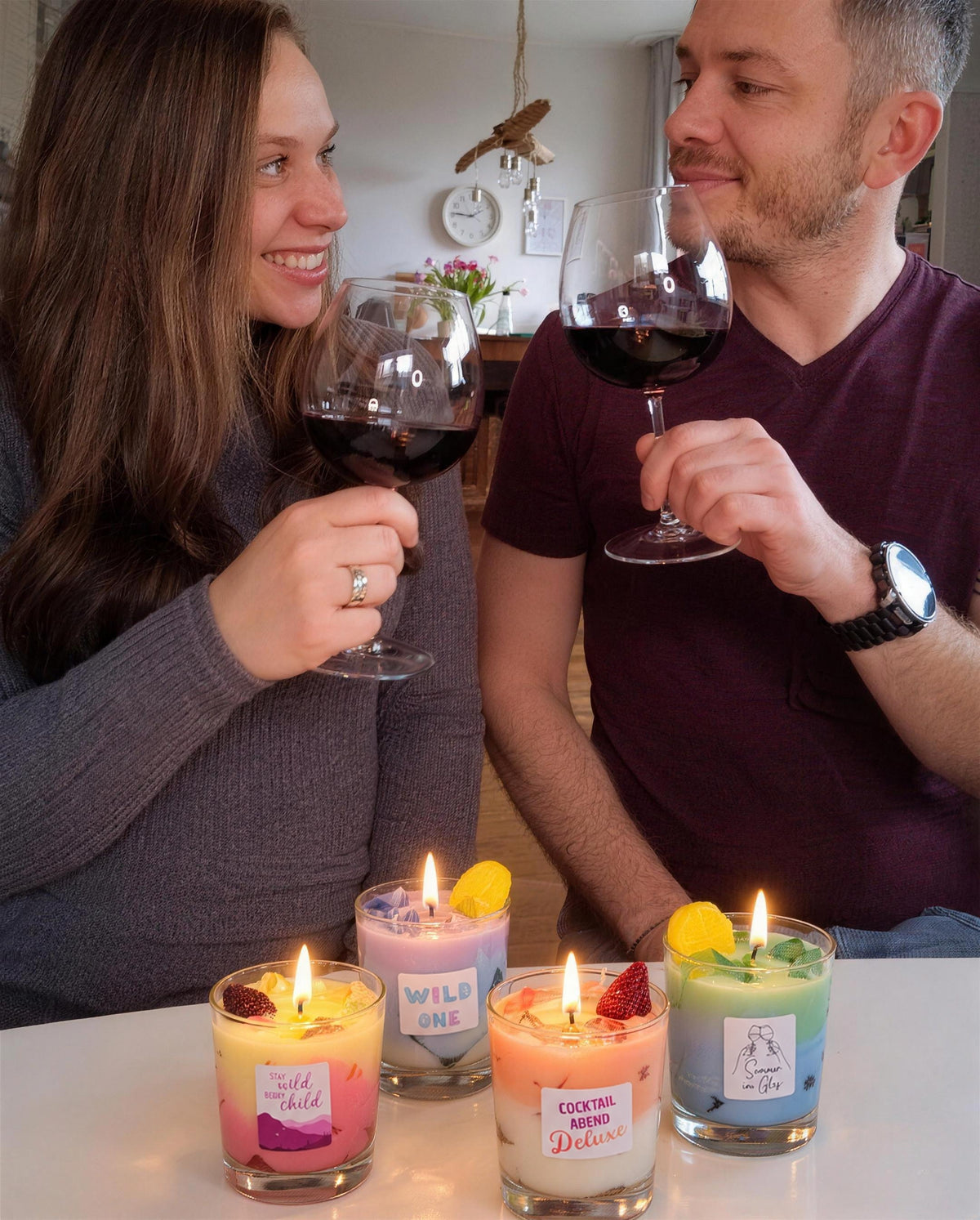 Paar stößt bei Kerzenschein an – vier selbstgemachte Cocktailkerzen aus dem Set Bunt