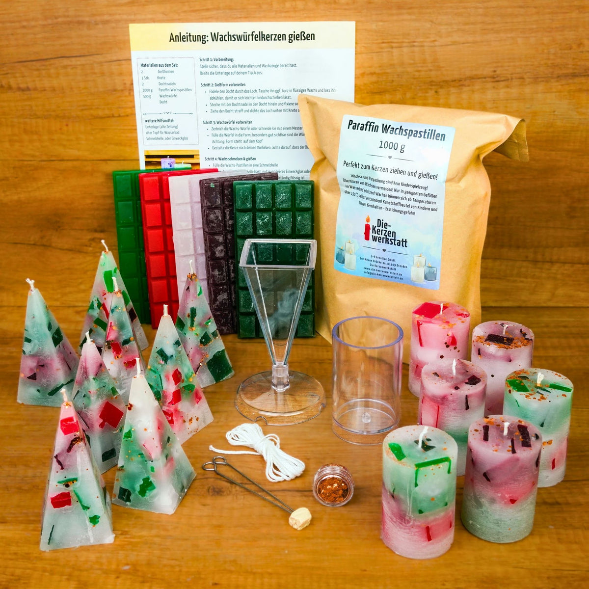 Alle 14 gegossenen Weihnachtskerzen – Pyramiden und Zylinder – neben Anleitung, Wachstafeln, Gießformen und Wachsbeutel