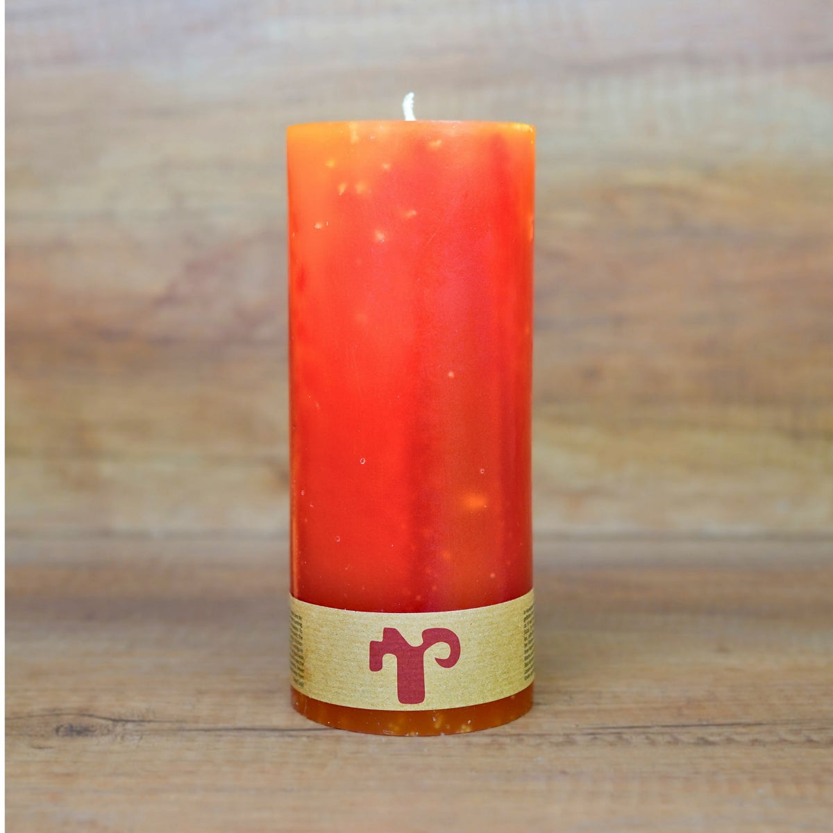 Lotus Blütenkerze in Orange, 29 cm hoch, vor dem ersten Anzünden auf Holztisch