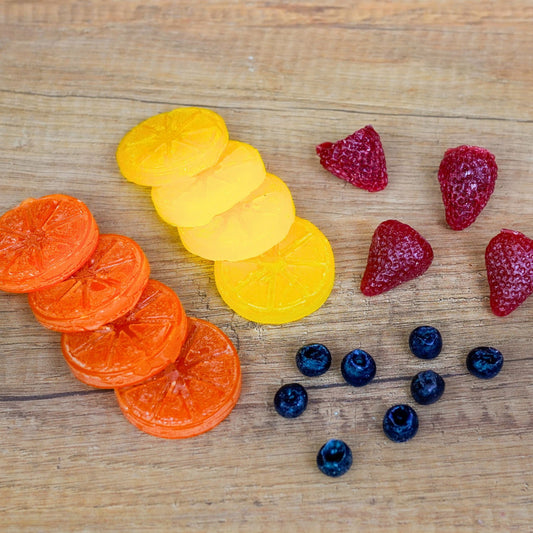 Gegossene Wachsfrüchte aus allen drei Formen: Orangen- und Zitronenscheiben, Erdbeeren und Blaubeeren